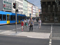Ampelgeregelte Kreuzungsüberquerung mit Verkehrsinseln und Straßenbahnschienen