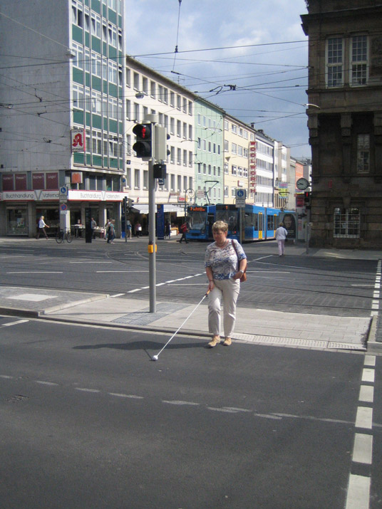 Ampelgeregelte Kreuzungsüberquerung mit Verkehrsinseln und Straßenbahnschienen